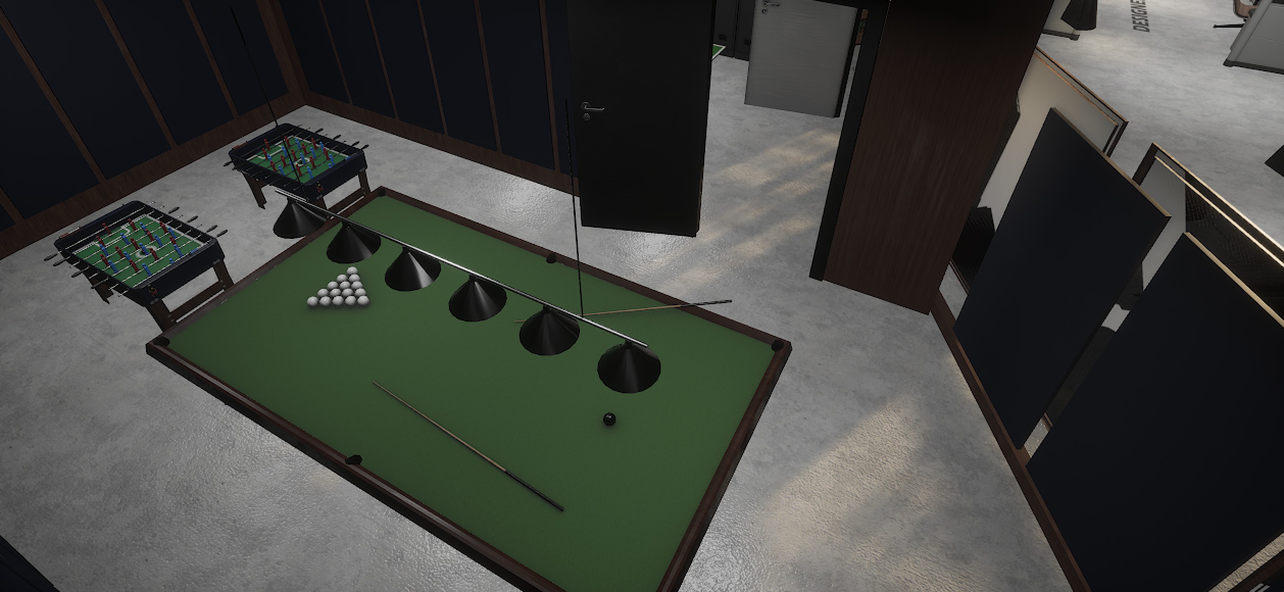 Closeup of a green pool table with racked balls and cue beside two foosball tables